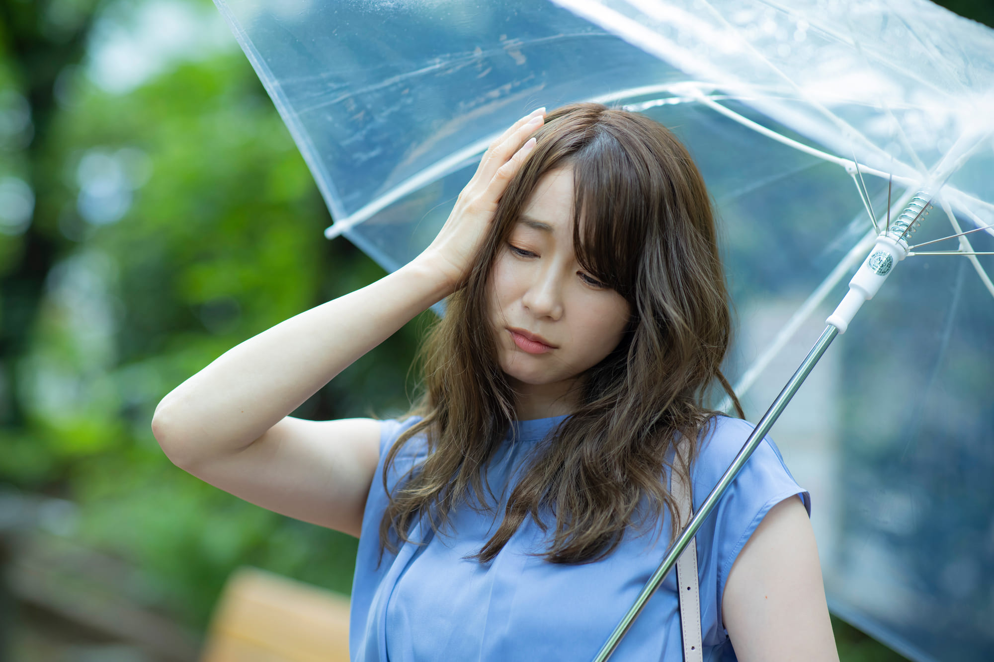 雨の影響で不調な女性